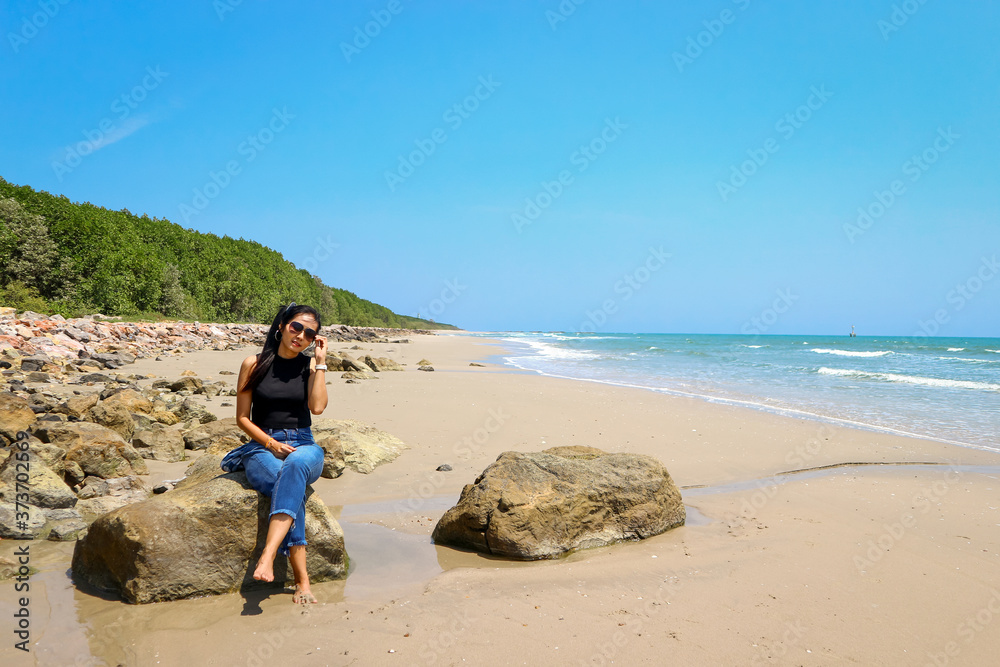 A girl sitting on a rock at the beach