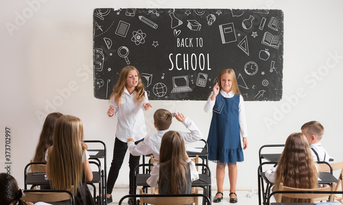 School children in classroom at lesson with worlds Back to school on classboard. Back to school, education, learn, lifestyle, childhood concept. Cheerful girls and boys during first studying day. photo