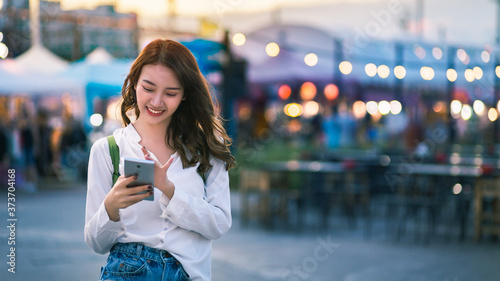 Photography Traveler asian woman using mobile phone and travel in Thailand shopping street m