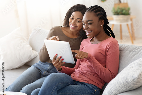African young women using digital tablet together