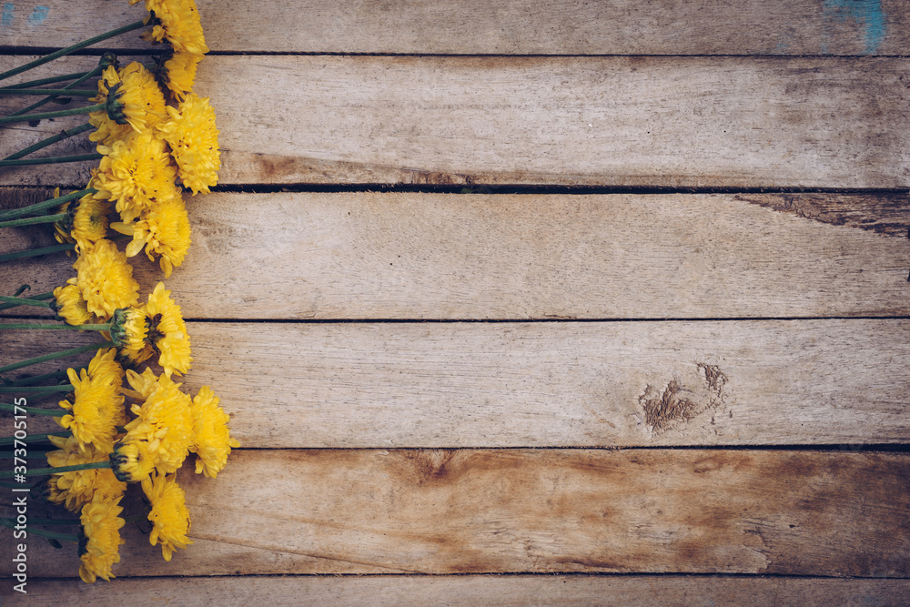 Yellow flowers of bouquet, top view on wooden background texture with copy space