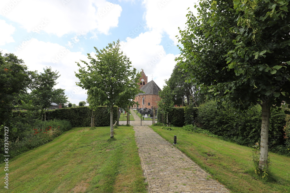 Beautiful caracteristic clinker path to a traditional Dutch old church. Photo was taken on a sunny day in summer.