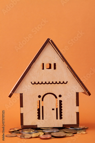 Miniature house model and coins. House buying and mortengage concept.