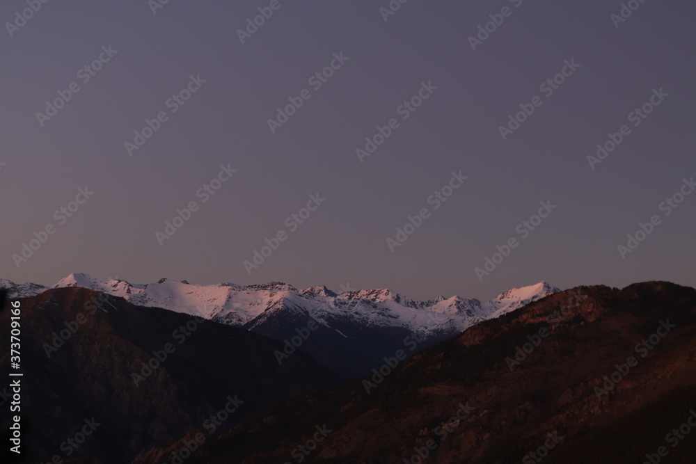 Mountain range covered in white snow at sunset