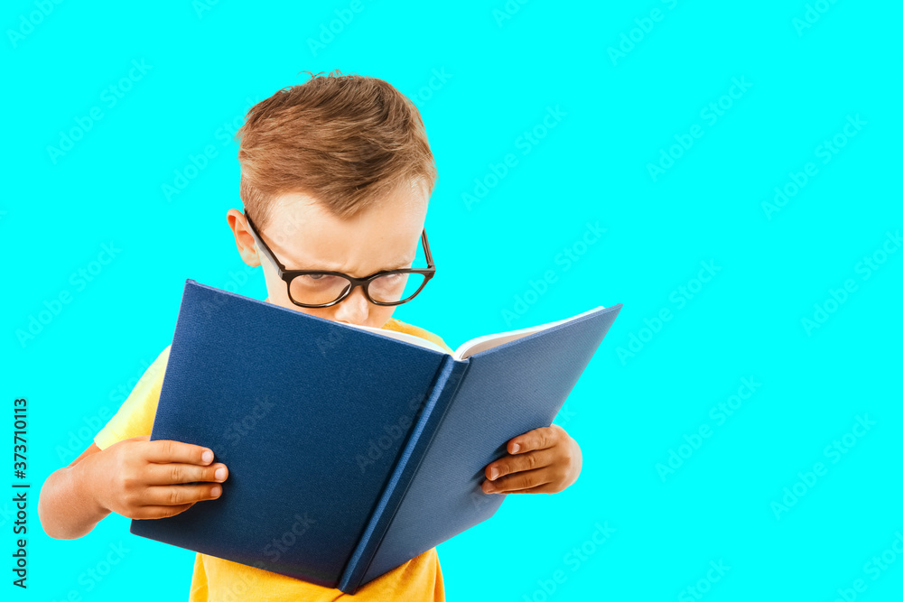 child reads a book against a bright wall child reads a book against a bright wall