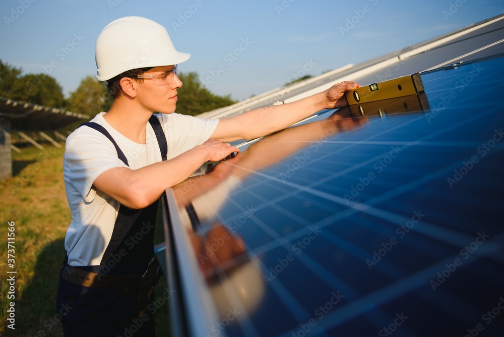 Worker installing solar panels outdoors Worker installing solar panels outdoors
