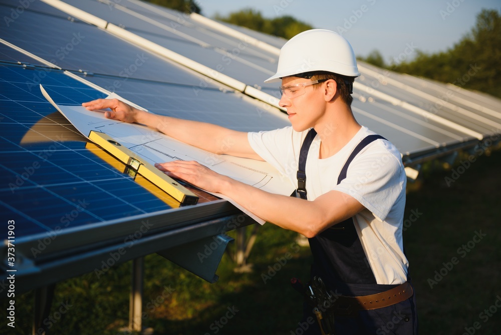 Worker installing solar panels outdoors Worker installing solar panels outdoors