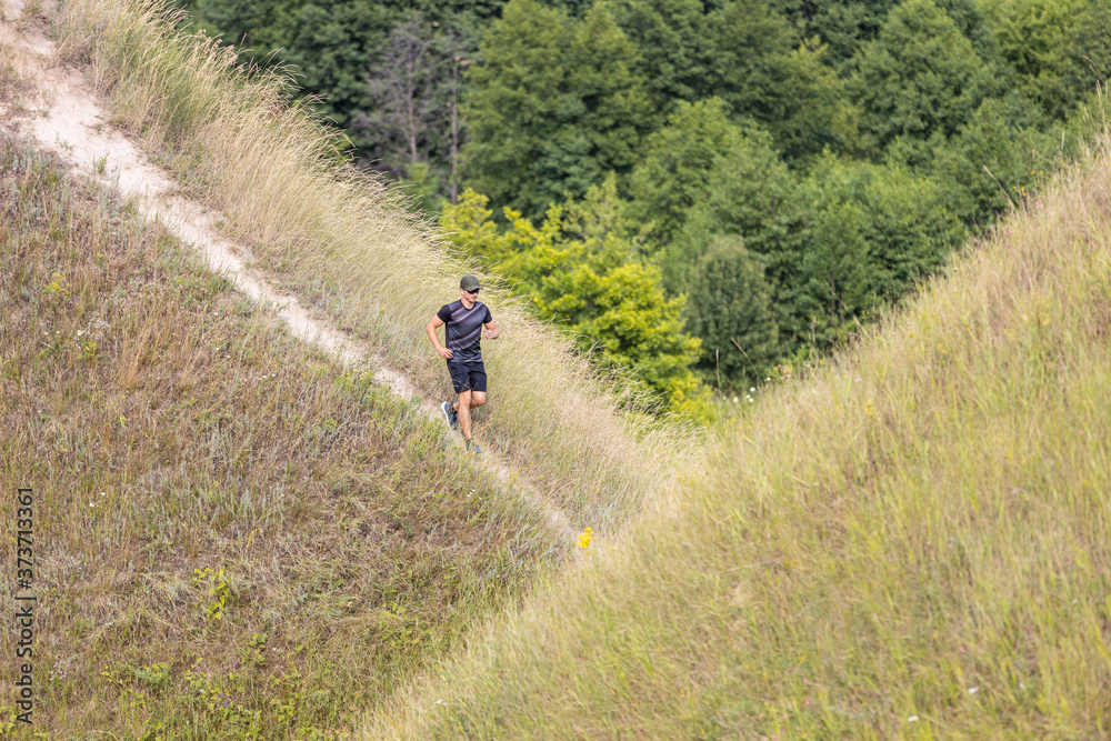 Young man running downhill in nature park Young man running downhill in nature park