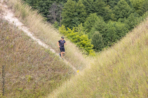 Young man running downhill in nature park © skumer