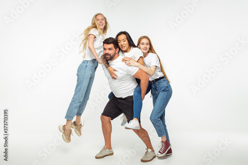 Group of adorable multiethnic friends having fun isolated over white studio background. Copyspace. Diversity, inclusion, friendship and love concept. Different nationalities united with sincere