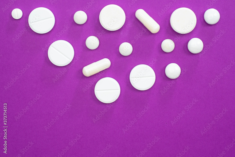 White pills on a lilac background. Medical treatment of diseases. Scheme of treatment of the disease. Medical recommendations. Prescribing pills to the patient. White pills on a lilac background. Medical treatment of diseases. Scheme of treatment of the disease. Medical recommendations. Prescribing pills to the patient.