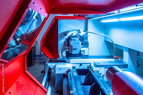 Industrial production. Equipment of the machine-building enterprise. Automated production of parts for cars. The machine is protected by a red casing. Production in automatic mode.