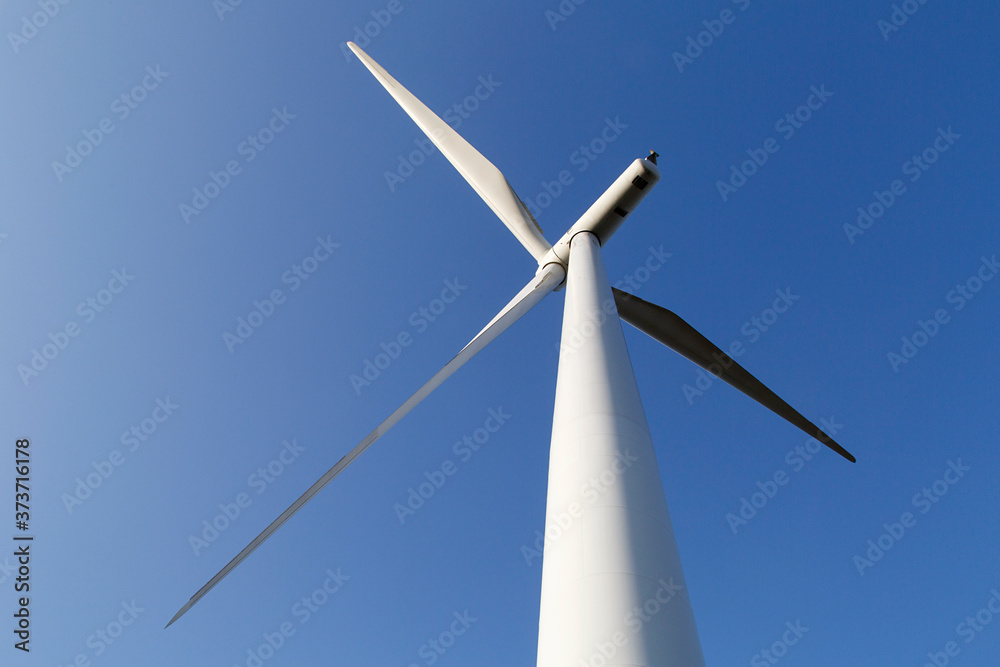 Single wind turbine with blue sky background from directly below. Single wind turbine with blue sky background from directly below.