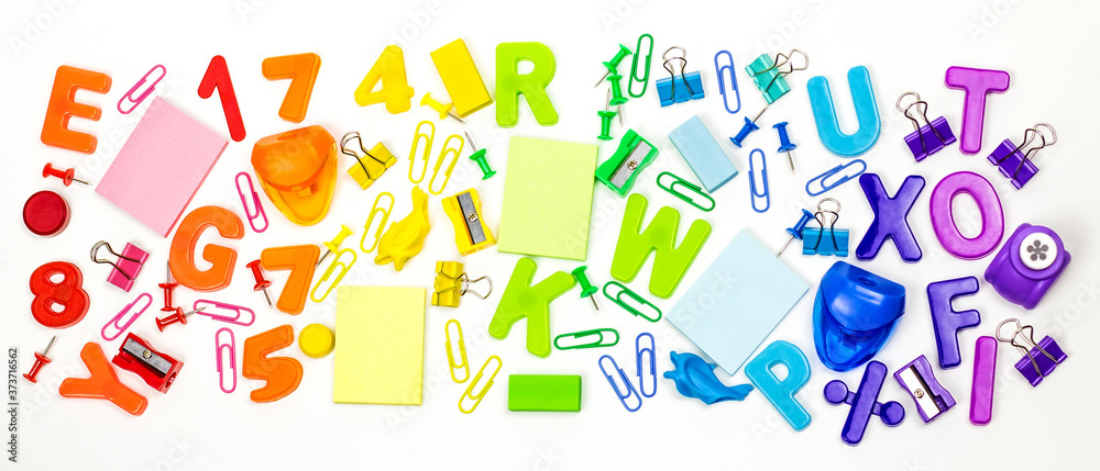 School supplies are laid out in the form of a rainbow. Light background. Arts and crafts for children. The child learns rainbow colors, letters of the alphabet and numbers.