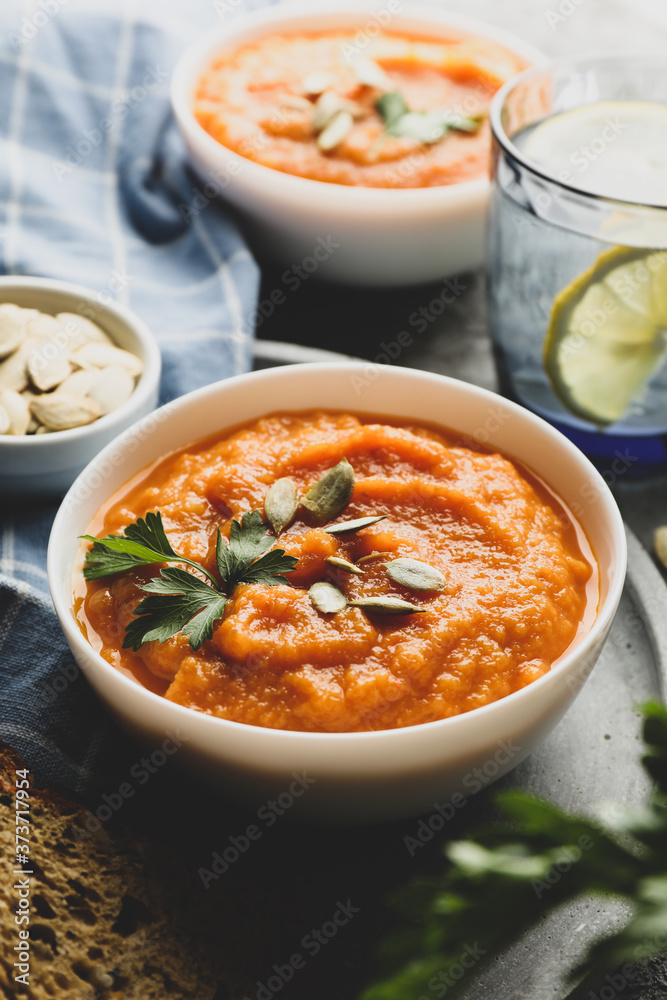Composition with pumpkin soup on gray background, close up Composition with pumpkin soup on gray background, close up