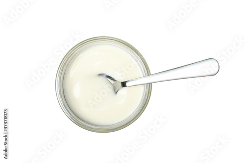 Glass jar of sour cream yogurt and spoon isolated on white background