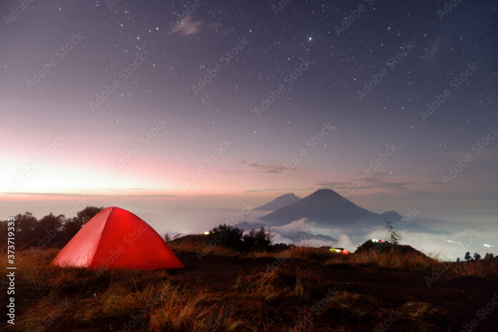 Camping on the mountain with a beautiful view of the mountains and stars at sunrise