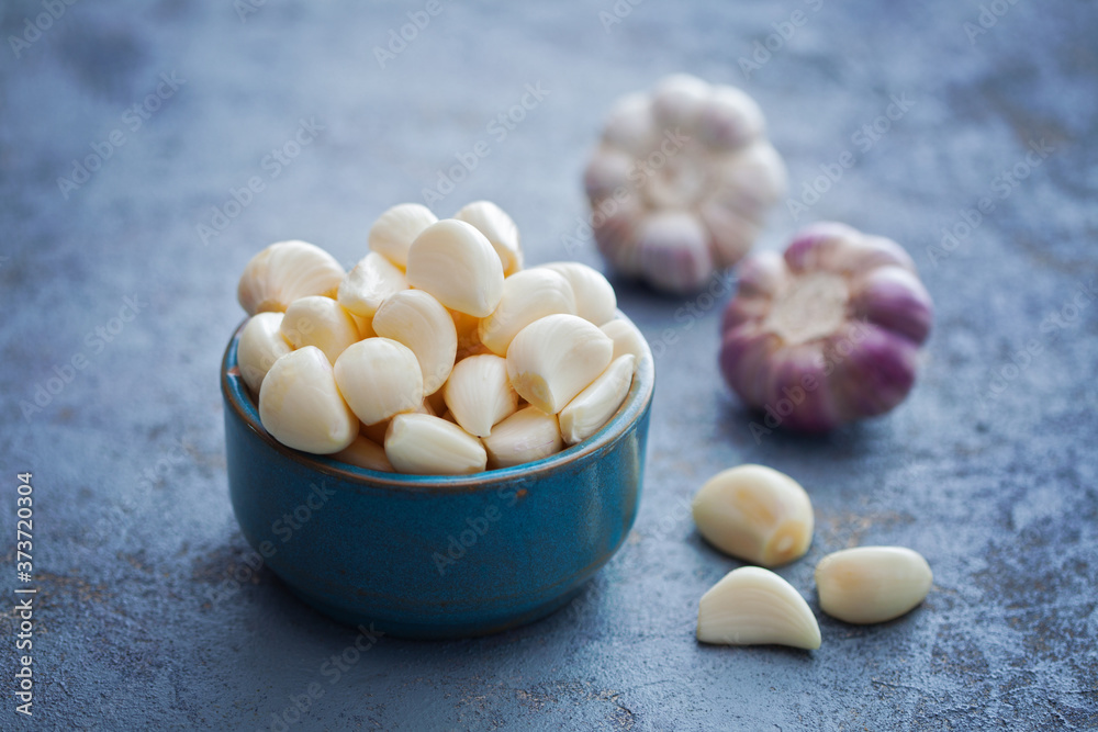 bowl with garlic cloves and head on board bowl with garlic cloves and head on board