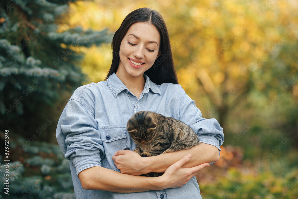 Girl in a summer park. Woman in a blue shirt. Lady with little kitty. Girl in a summer park. Woman in a blue shirt. Lady with little kitty.