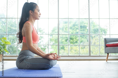 Free Download Young asian woman doing yoga exercises at home. - GFXLoad