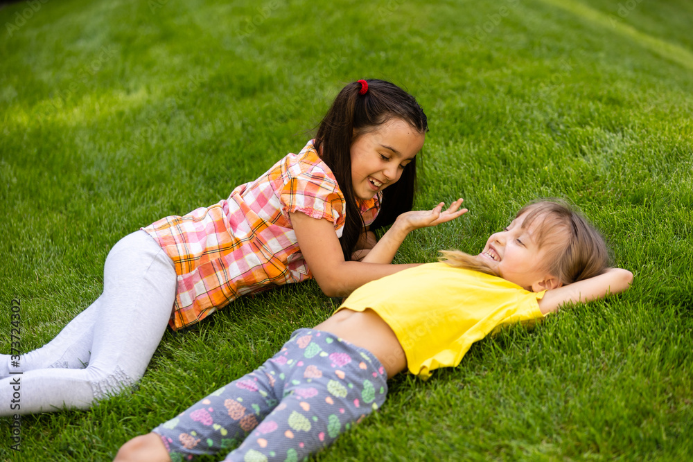 Portrait of two little girls sisters fighting on home backyard. Friends girls having fun. Lifestyle candid family moment of siblings quarreling playing together. Portrait of two little girls sisters fighting on home backyard. Friends girls having fun. Lifestyle candid family moment of siblings quarreling playing together.