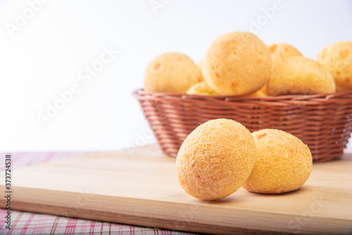 Cheese bread "Pão de queijo" Brazil, on a table with checkered tablecloth and accessories, selective focus.