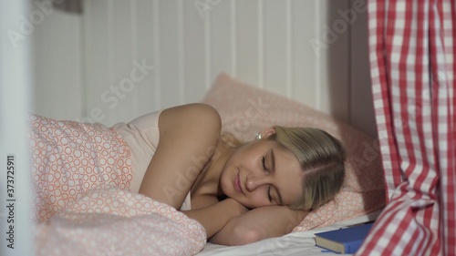 Young woman sleeps in cozy hostel room
