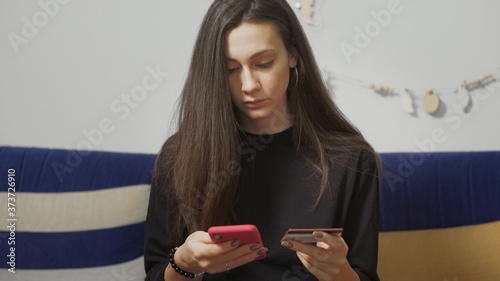 Beautiful woman using credit card for online shoping on her smartphone