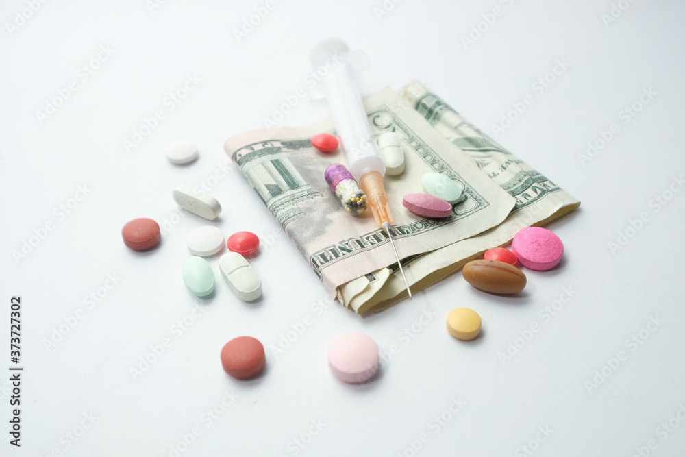 Healthcare cost concept with us dollar, syringe and pills Healthcare cost concept with us dollar, syringe and pills