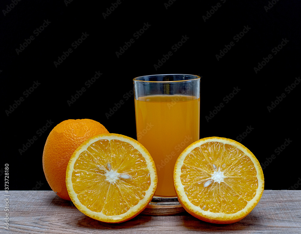 Orange juice in a glass and an orange fruit on the ground Orange juice in a glass and an orange fruit on the ground