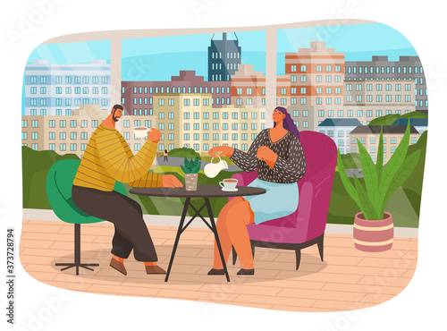 Friends or business partners are sitting in cafe or restaurant near big panoramic window at a table drinking coffee, have dinner. Cheerful man and woman at home together talking, communicating