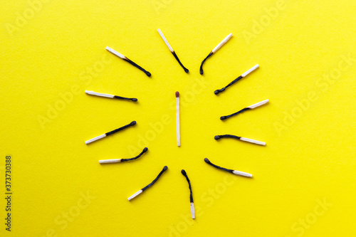 Group of burnt out and one unused match sticks on yellow background. Preventing of coronavirus / Covid-19 spread by self quarantine. Social distance concept. Stopping the domino effect. Save a commun