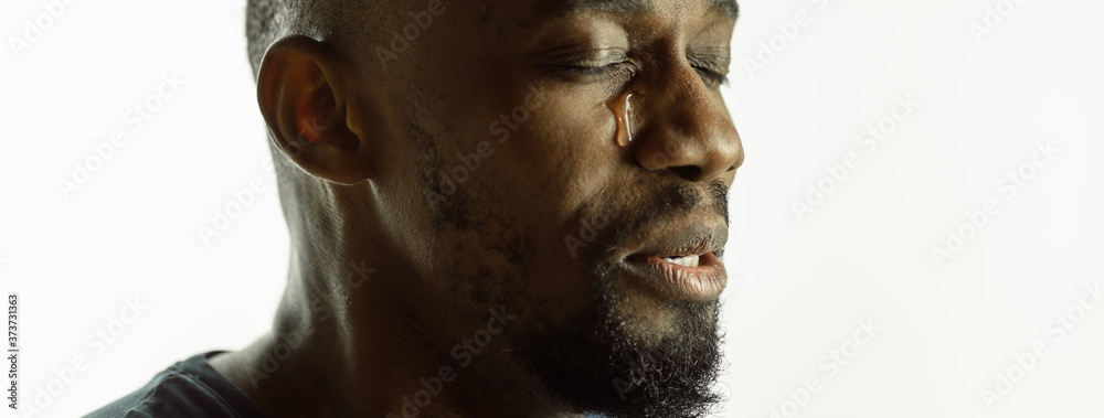 Crying. African-american young man's close up shot on studio background, flyer. Concept of human emotions, facial expression, sales, ad. Copyspace. Beautiful male model with bright expression. Crying. African-american young man's close up shot on studio background, flyer. Concept of human emotions, facial expression, sales, ad. Copyspace. Beautiful male model with bright expression.