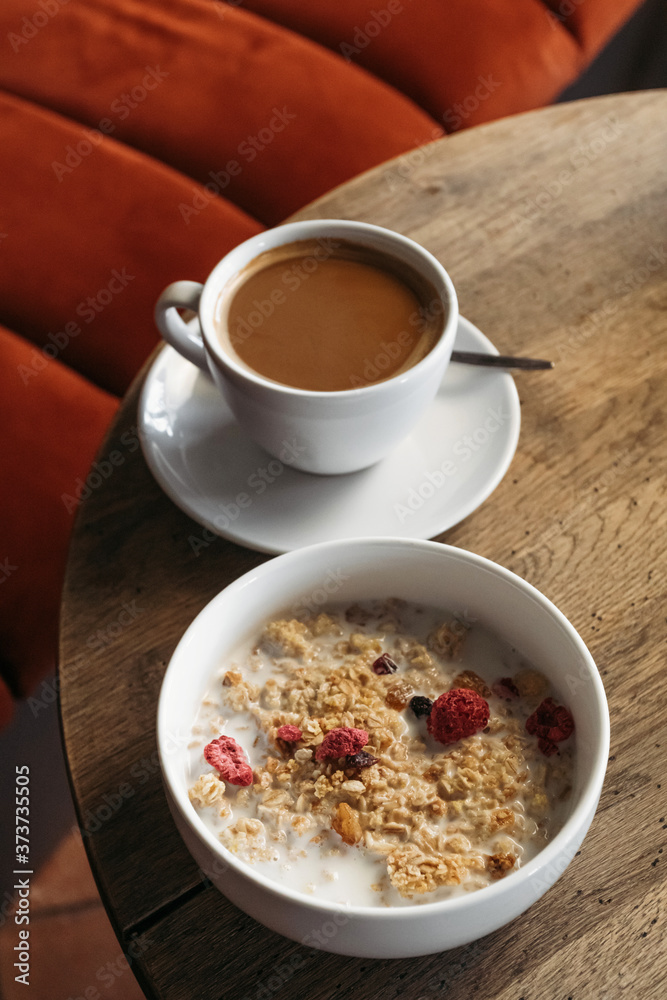 Breakfast at the cafe. Muesli with milk and cup of cappuccino. Breakfast at the cafe. Muesli with milk and cup of cappuccino.