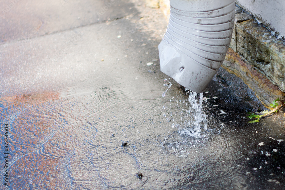 Φωτογραφία A stream of water pours down the drainpipes from the roofs of houses