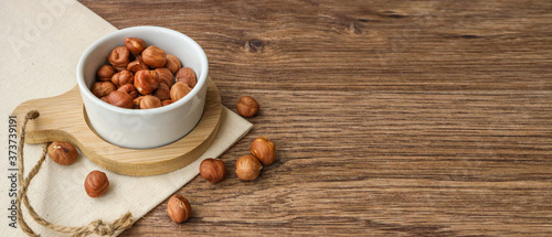 hazelnuts on a plate, on a wooden background with place for text on the right