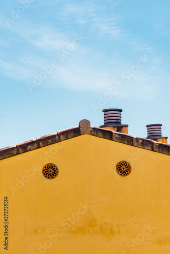 Yellow house wall and blue sky. Contrast blocks. abstract background, pareidolia effect.