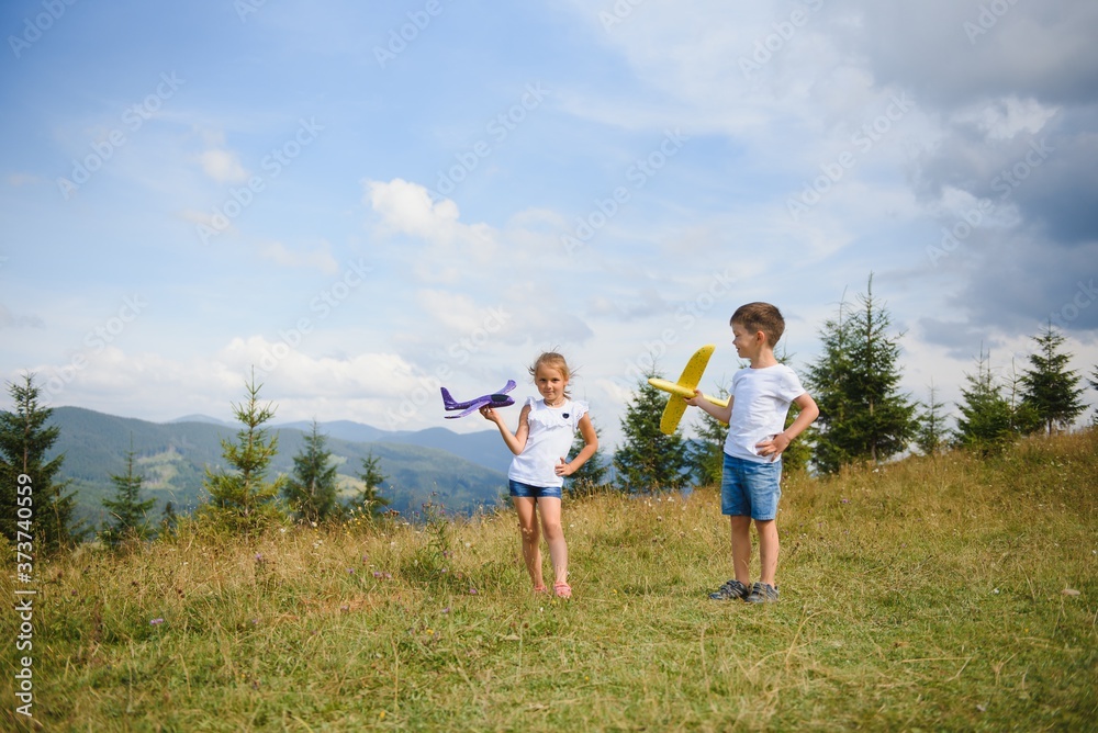 Children pilot aviator with airplane dreams of traveling in summer in nature. Vacation concept.