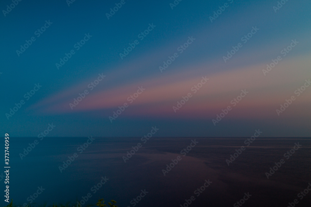 灯台の見える海の地平線。夕暮れ時