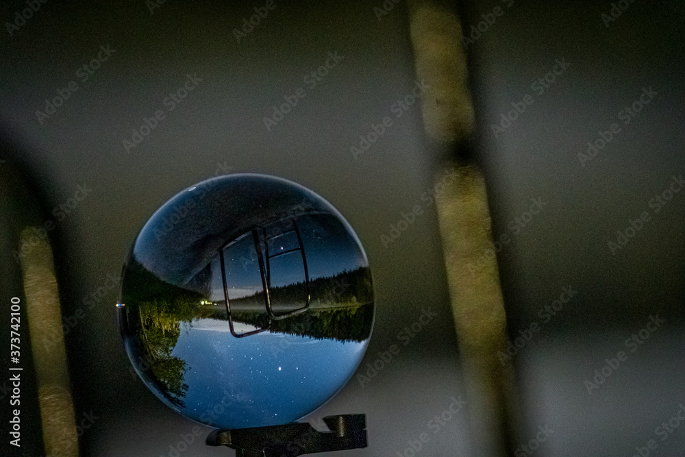 Milkyway captured in a little lensball in front of a lake.