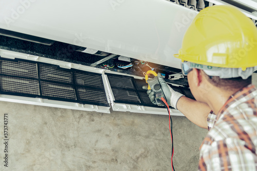 Technician - Engineer investigate Repairing Air Conditioner photo