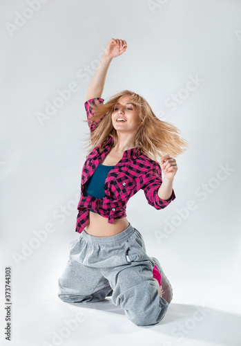 Young beautiful Hip-Hop girl dancing on a white studio background