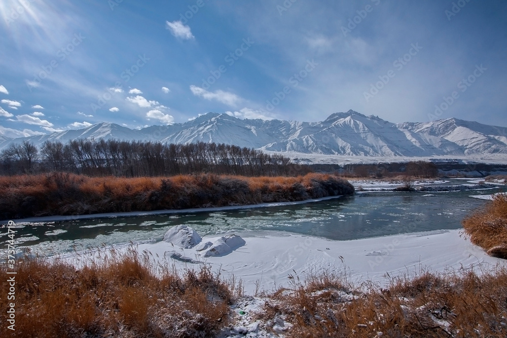 High altitude winter landscape with snow peaks and frozen river in Leh Ladakh in India