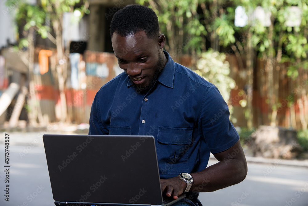 portrait of a smiling young man with laptop.