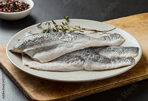 Raw sea bass fillet on a plate, seafood.