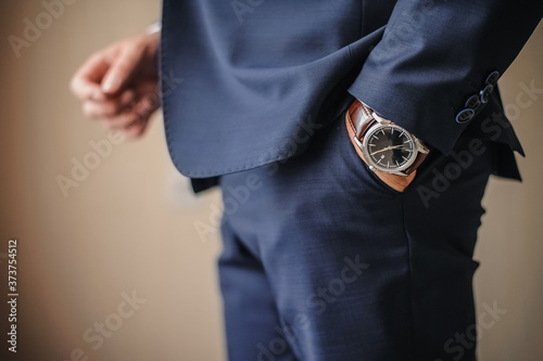 a man in a suit stands with his hand in his pocket