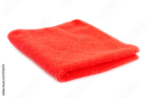 Red beach towel on a white background with shadow. Towel isolated on a white background. Folded beach towel in red. Summer vacation concept.