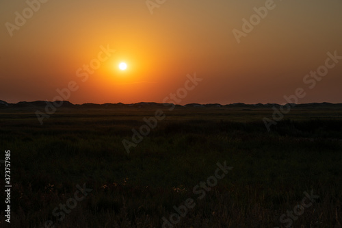 Sunset over the grassland between the dike and the beach on the North Sea coast.
