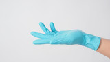 Empty hand with blue latex glove on white background.