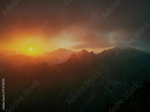 Cloudy mountain peaks at sunrise. Tatry Poland, Rysy on the right.